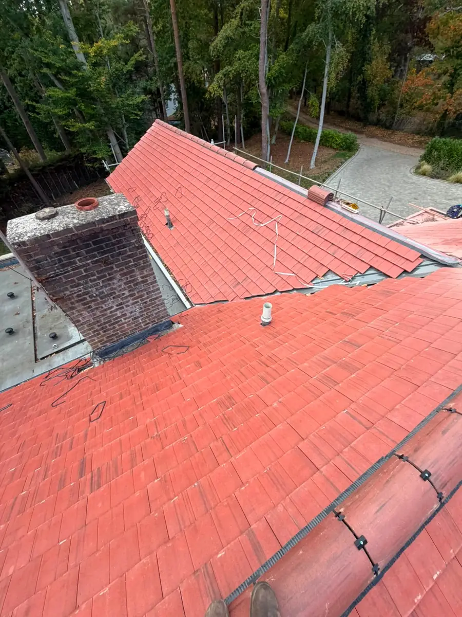 New tiles cut neatly around the brick chimney on the Fleet roof
