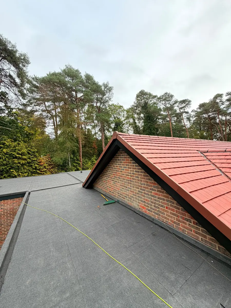 New flat roof dressed up against the brick gable of the main roof in Fleet