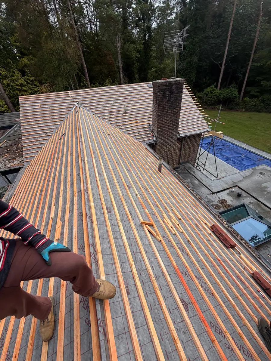 New battens running up to the hip on the Fleet re-roof with the chimney behind