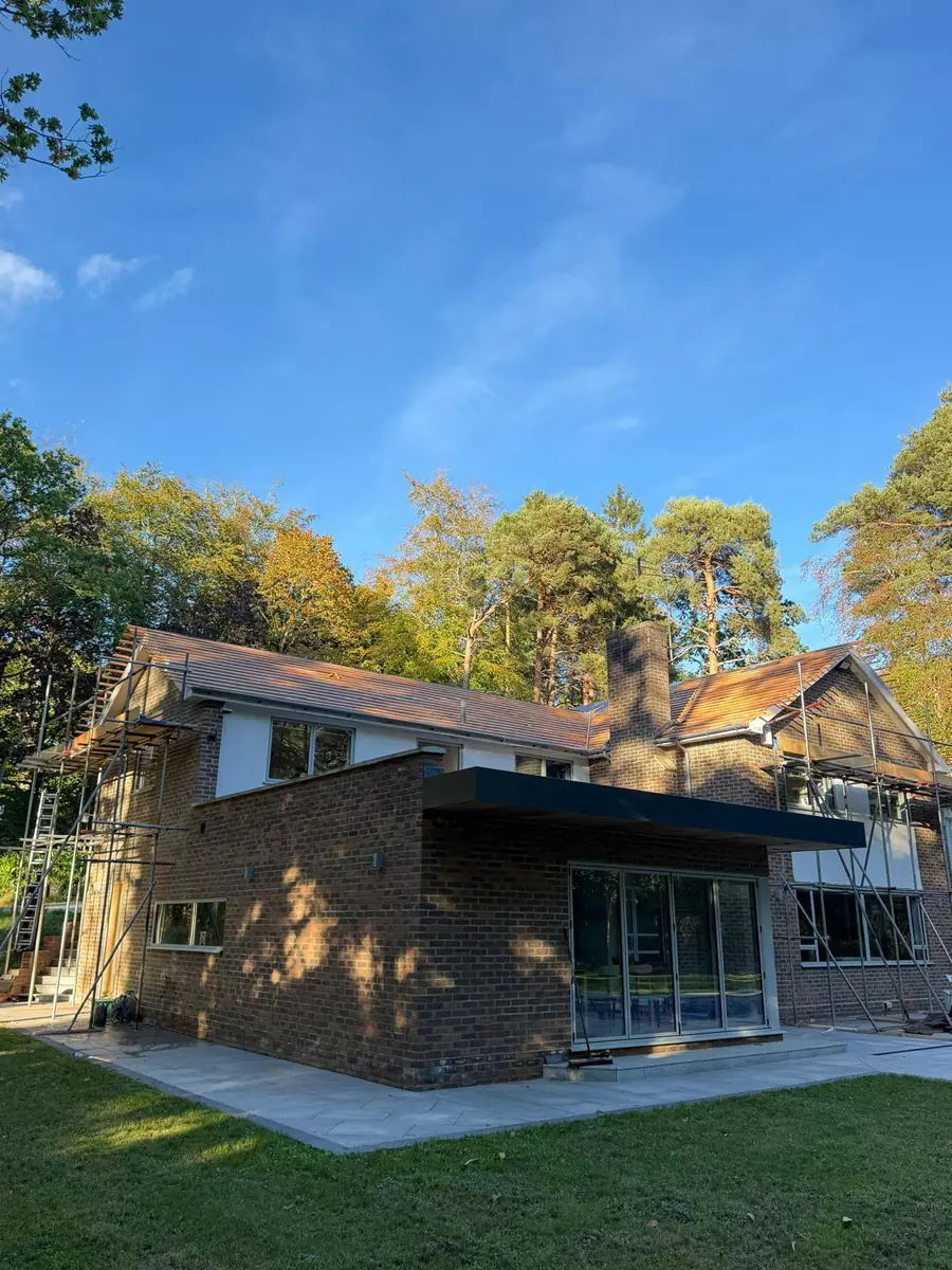 Rear of the Fleet property under scaffold with mature pine trees behind