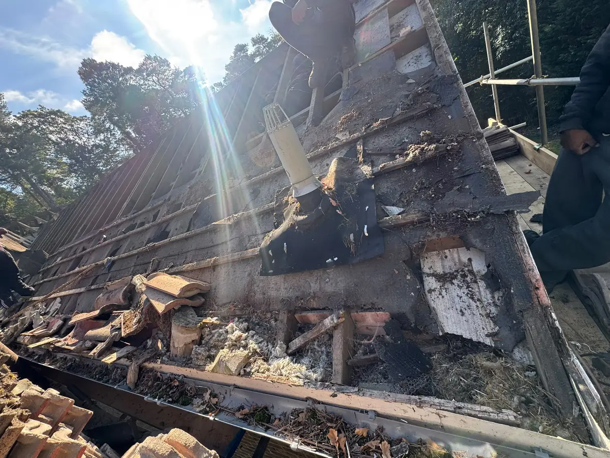 Old tiles and battens being stripped from the roof in Fleet with debris at the eaves