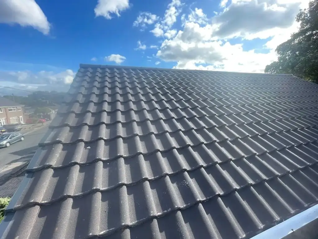 Grey interlocking concrete tiles laid in straight courses on a recent re-roof