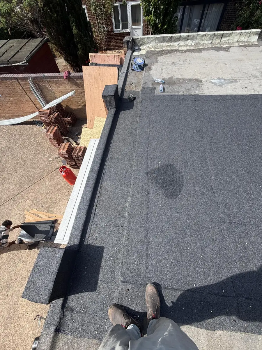 New felt flat roof in Hampton with the old stripped tiles stacked in the garden below
